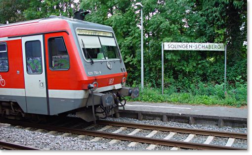 Das Foto zeigt den rot lackierten Triebwagen der Regionalbahn mit dem Namen 'Mngstener' am Haltepunkt Solingen Schaberg