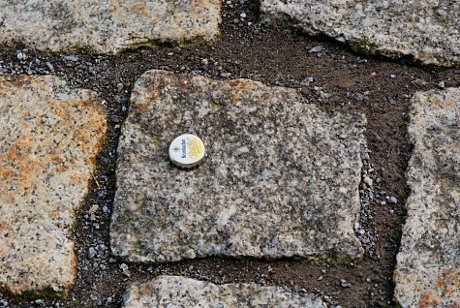 Foto: achtlos entsorgter Kronkorken auf Granit
